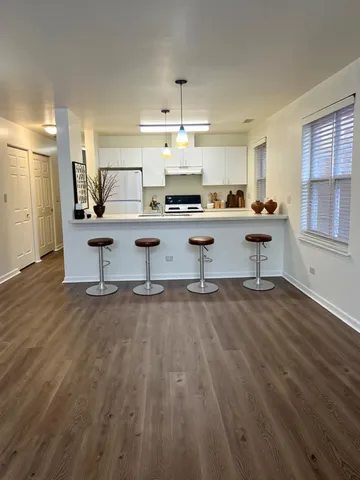 a living room with kitchen island furniture and a chandelier