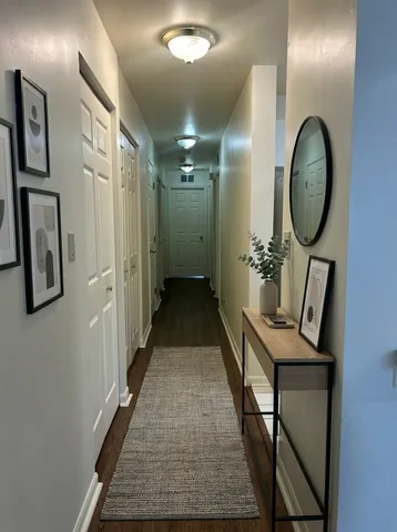 a view of a hallway with entryway wooden floor and front door