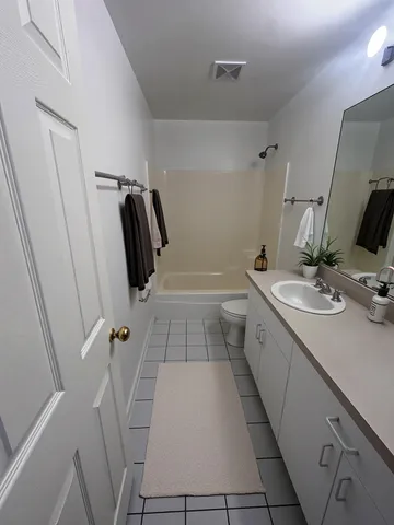 a bathroom with a sink a toilet a mirror and shower