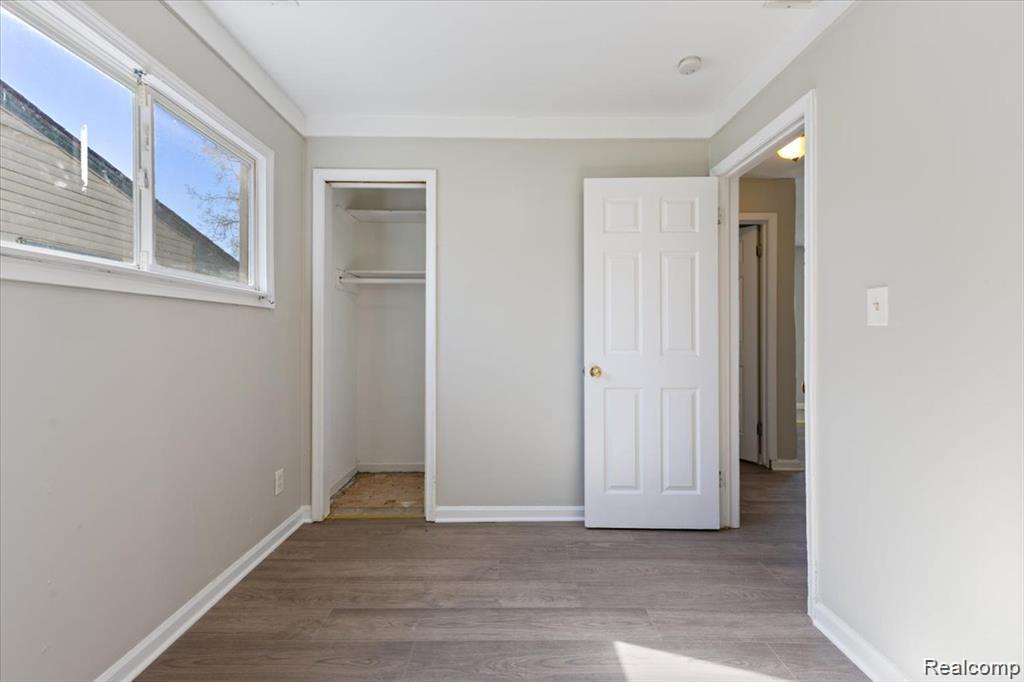 26076 Colgate Street Inkster, MI 48141 - Photo 14 of 24 Room featuring wood-finish flooring, light grey painted walls, white trim, and a window with white framing