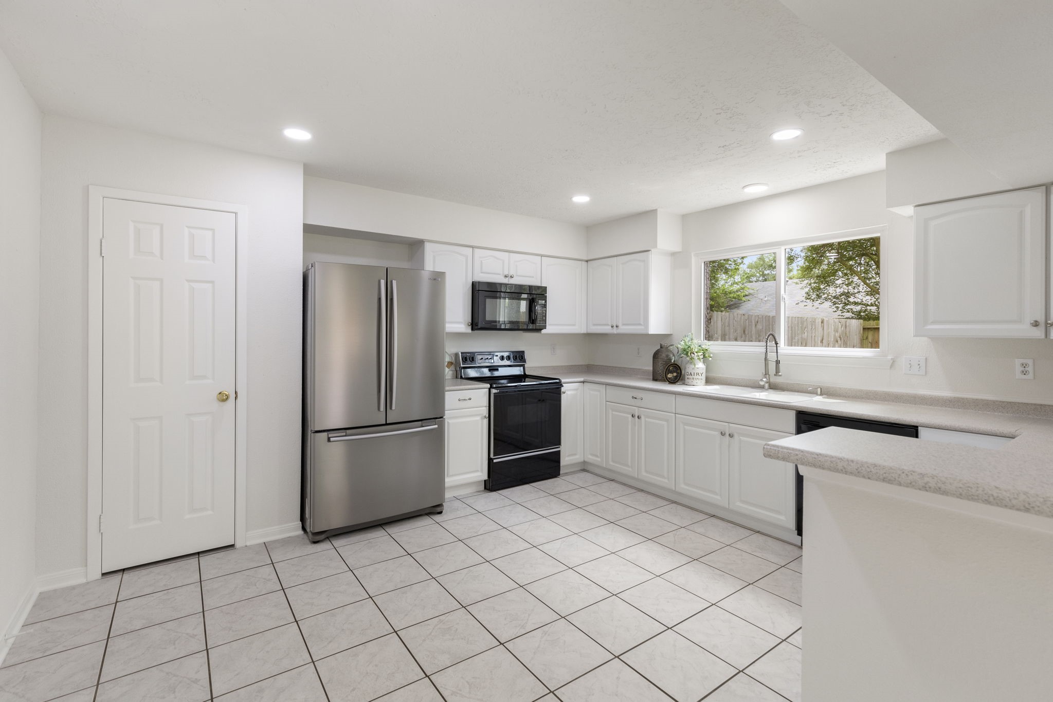 4715 Towermont Lane Spring, TX 77388 - Photo 10 of 35 The kitchen features a large pantry, tile floor, updated lighting and awesome backyard views.