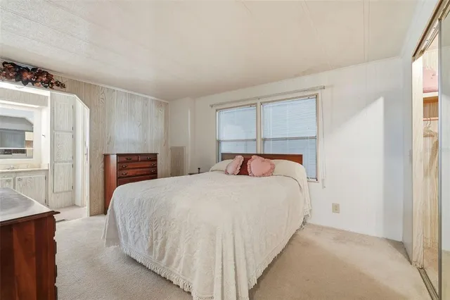 a bedroom with a bed and a refrigerator