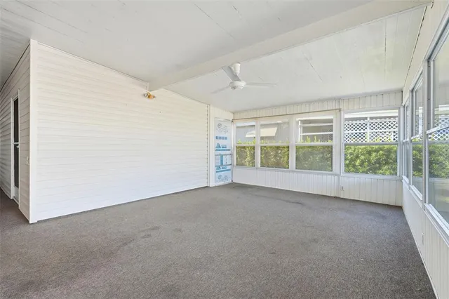 a kitchen that has a lot of white cabinets and stainless steel appliances