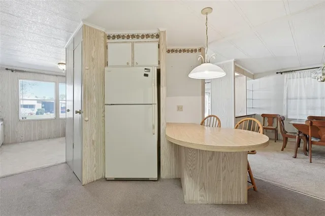 a kitchen with stainless steel appliances granite countertop a dining table chairs sink and cabinets