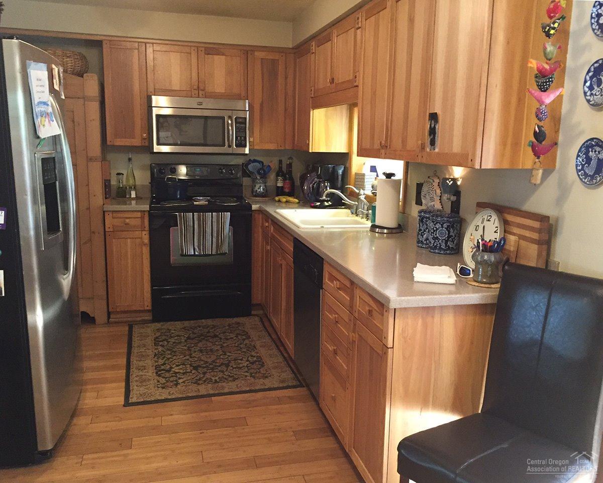 59968 Hopi Road Bend, OR 97702 - Photo 3 of 12 a kitchen with stainless steel appliances granite countertop a refrigerator a stove a sink and a microwave