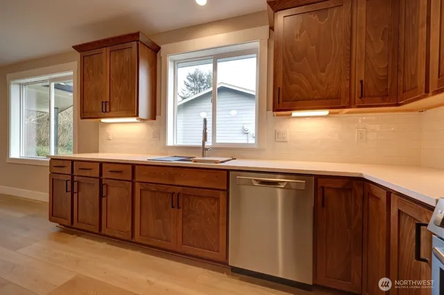 a kitchen with stainless steel appliances granite countertop wooden cabinets a sink and dishwasher