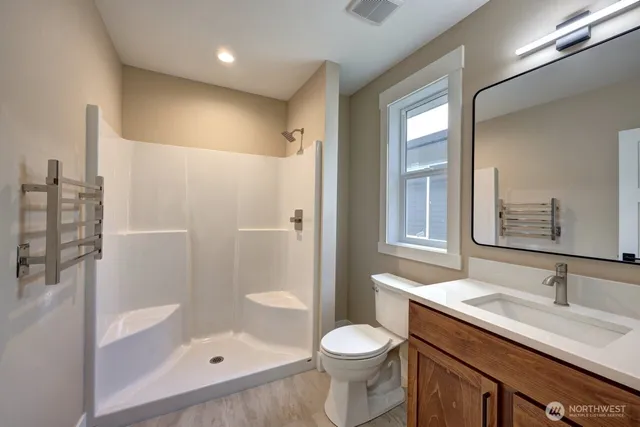 a bathroom with a sink a toilet and shower