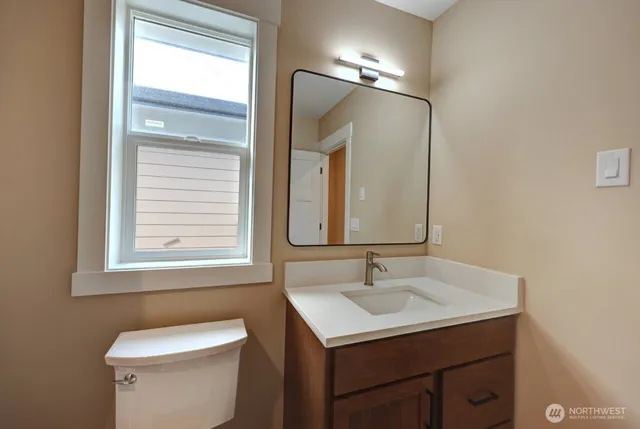a bathroom with a sink toilet and mirror