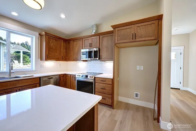 a kitchen with granite countertop a refrigerator stove top oven and sink