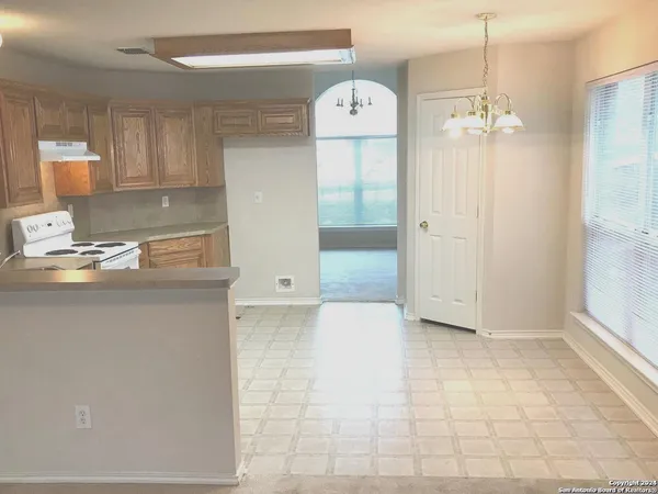 a view of kitchen with granite countertop cabinets and refrigerator