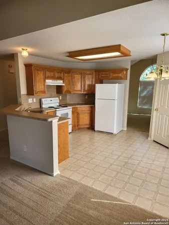 a kitchen with a stove top oven cabinets and a refrigerator