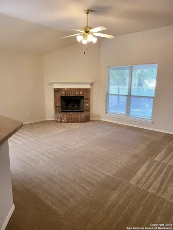 an empty room with windows and fireplace