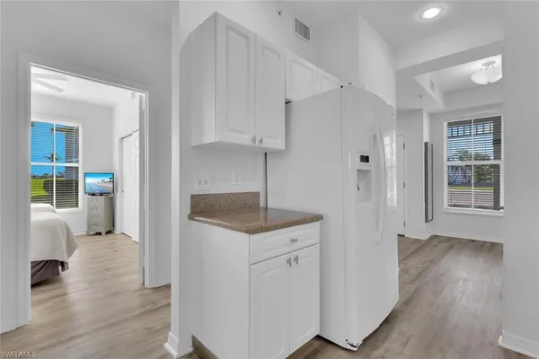 a kitchen with cabinets and wooden floor