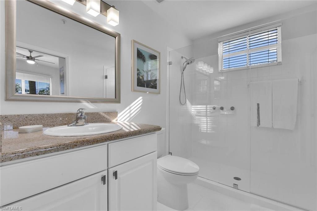 7895 Mahogany Run Lane, Unit 1416 Naples, FL 34113 - Photo 22 of 38 a bathroom with a granite countertop sink toilet and shower