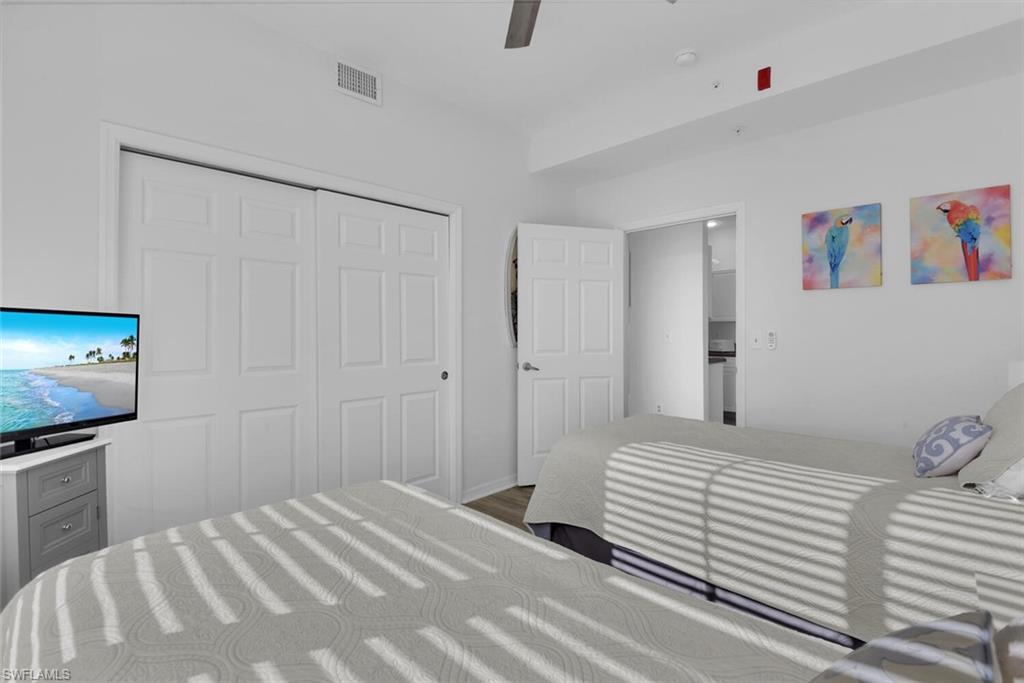 7895 Mahogany Run Lane, Unit 1416 Naples, FL 34113 - Photo 24 of 38 a bedroom with a bed and a flat screen tv