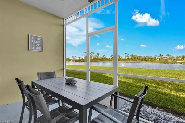 a view of a dining room with furniture a chandelier and a large window