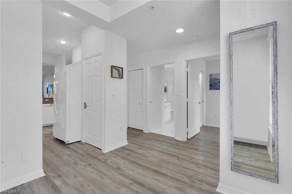 7895 Mahogany Run Lane, Unit 1416 Naples, FL 34113 - Photo 6 of 38 a view of a hallway with wooden floor