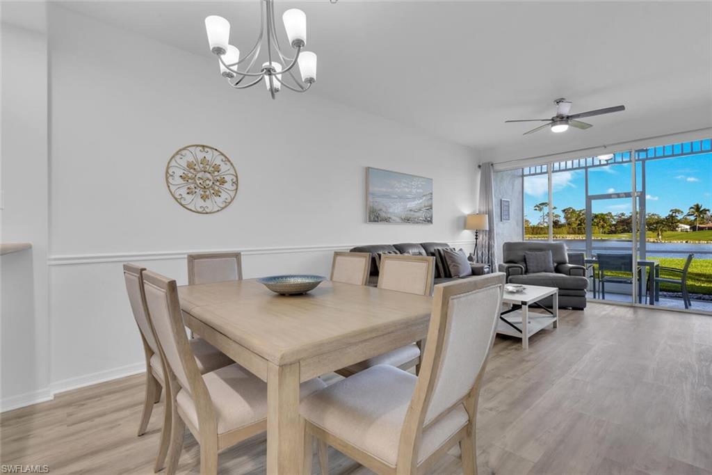 7895 Mahogany Run Lane, Unit 1416 Naples, FL 34113 - Photo 7 of 38 a view of a dining room with furniture a chandelier and wooden floor