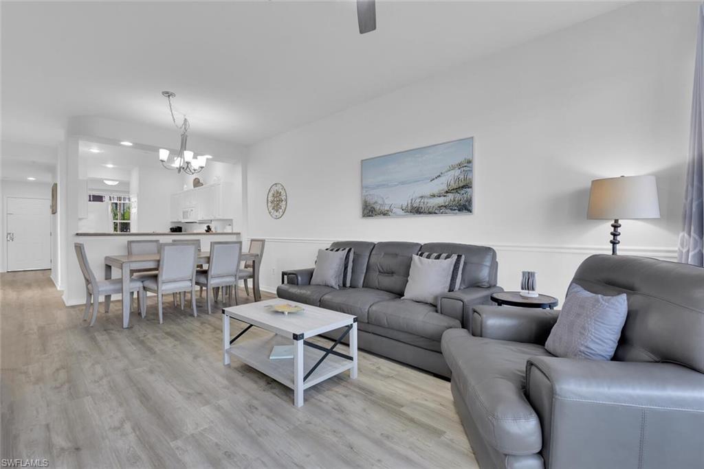 7895 Mahogany Run Lane, Unit 1416 Naples, FL 34113 - Photo 9 of 38 a living room with furniture and a chandelier