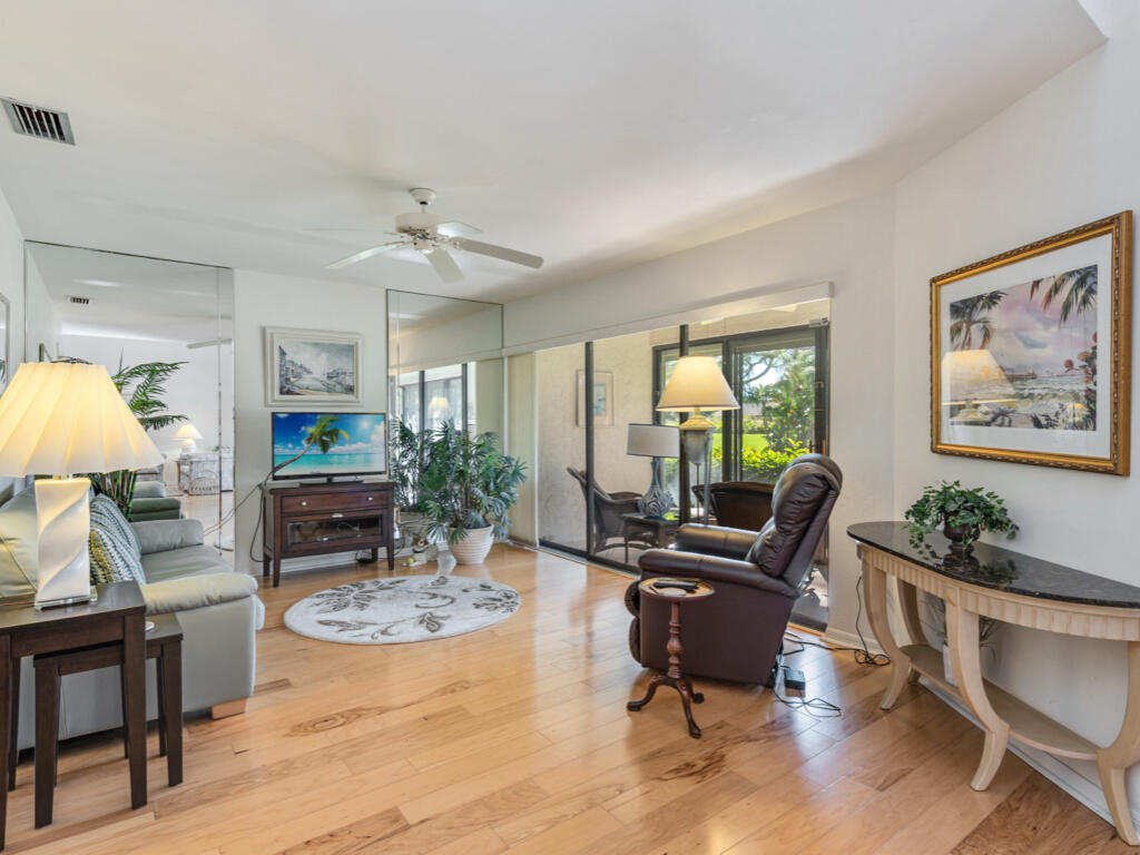 602 Augusta Boulevard, Unit 3 Naples, FL 34113 - Photo 2 of 8 a living room with furniture a piano and a flat screen tv