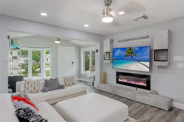 a living room with furniture a flat screen tv and a fireplace