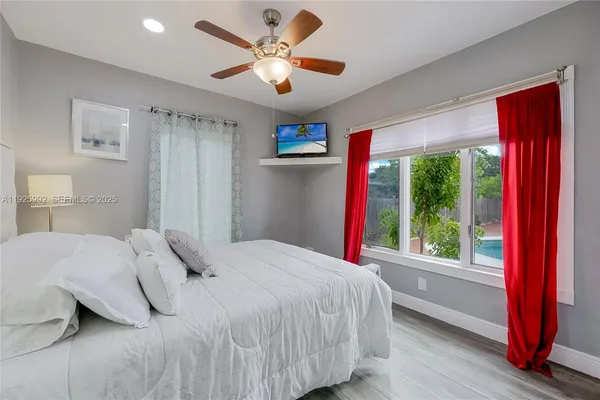 a bedroom with a large bed and a large window with the outer view