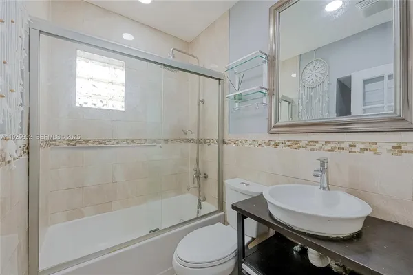a bathroom with a sink toilet a mirror and shower