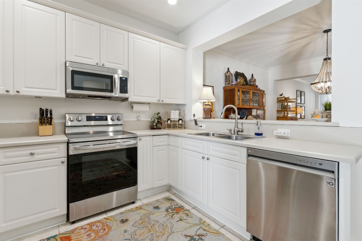 1824 Perimeter Park Road West Fernandina Beach, FL 32034 - Photo 7 of 24 a kitchen with stainless steel appliances granite countertop a sink and a stove top oven with white cabinets