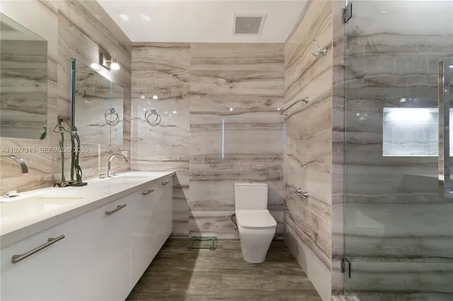 a bathroom with a double vanity sink toilet and shower