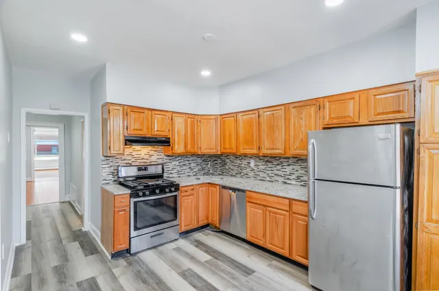 a kitchen with stainless steel appliances granite countertop a refrigerator a stove a sink and a microwave