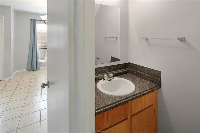 a bathroom with a granite countertop sink and a mirror