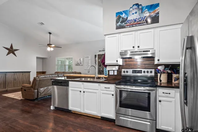 a kitchen with granite countertop stainless steel appliances and wooden cabinets