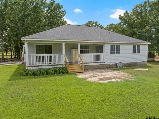 a front view of a house with yard and green space