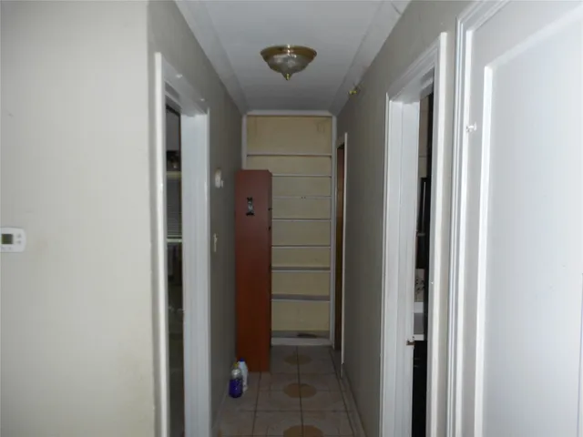 a view of a hallway with wooden floor and stairs
