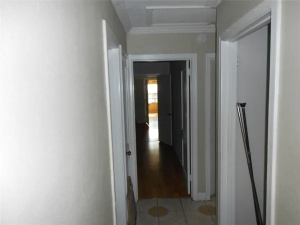 a view of a hallway with wooden floor and stairs