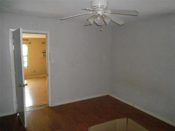 a view of a small space with wooden floor and a window