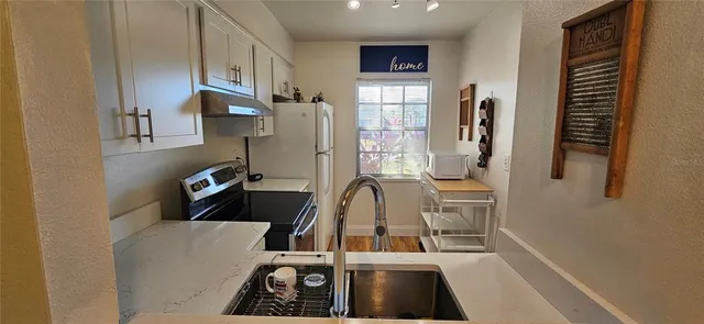 a view of a kitchen with refrigerator and windows