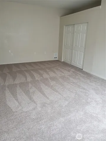 an empty room with closet and a bathroom