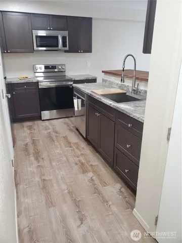 a kitchen with stainless steel appliances granite countertop a sink a stove and a refrigerator