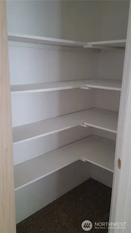 a view of walk in closet with empty racks