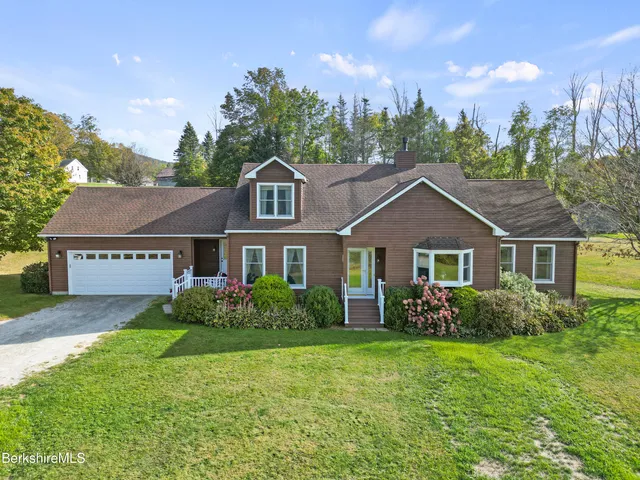 a front view of a house with a garden and yard