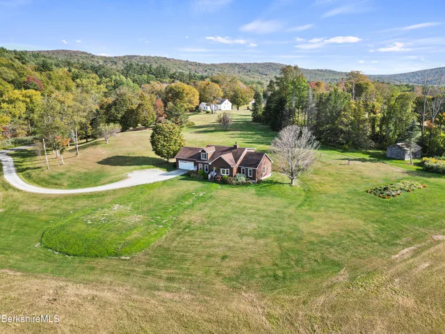 a kitchen with stainless steel appliances granite countertop a stove top oven a sink a dining table and chairs with wooden floor