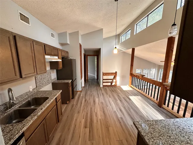 a kitchen with granite countertop a sink stove and refrigerator