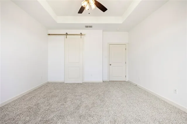 an empty room with a ceiling fan and a window