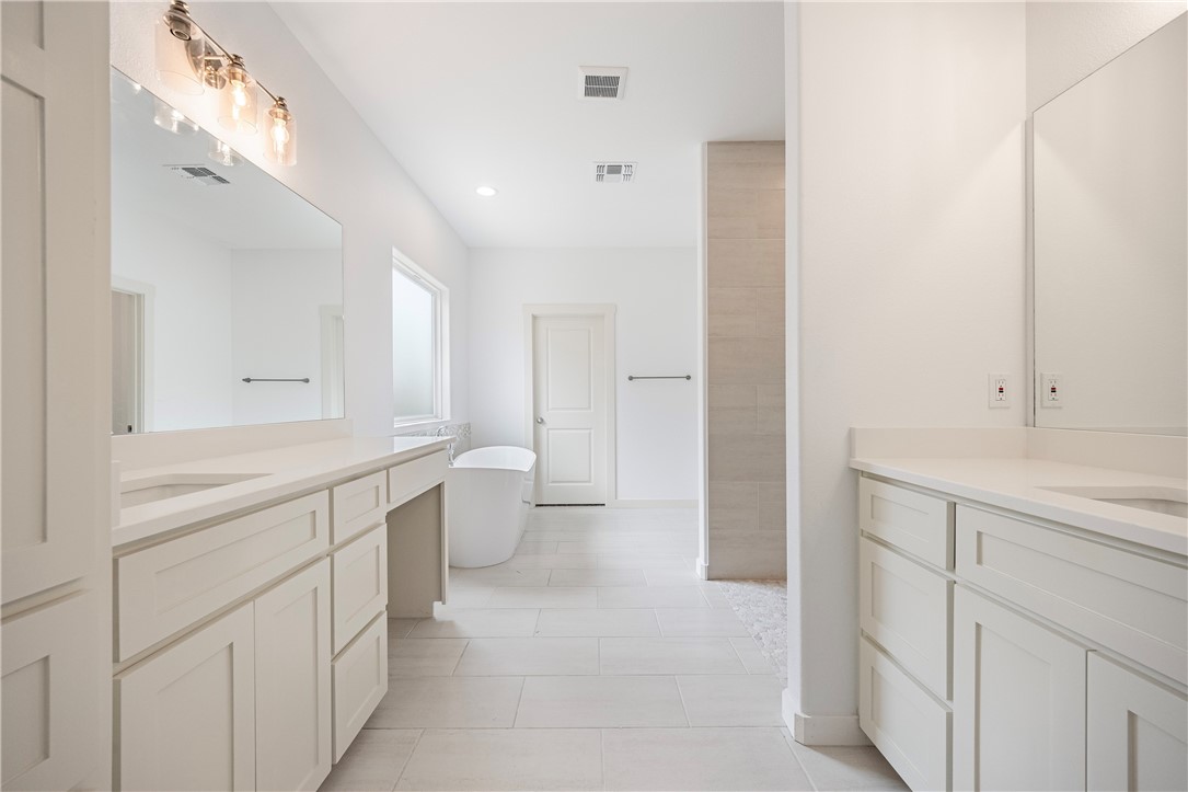 1702 Elm View Drive Corpus Christi, TX 78418 - Photo 12 of 27 a large white bathroom with a double vanity sink a toilet and a shower