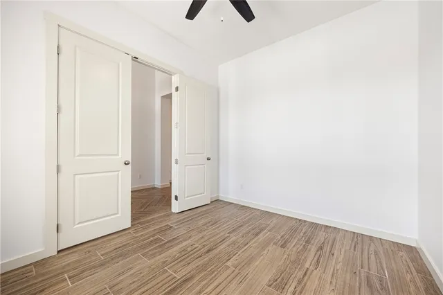 an empty room with wooden floor and closet