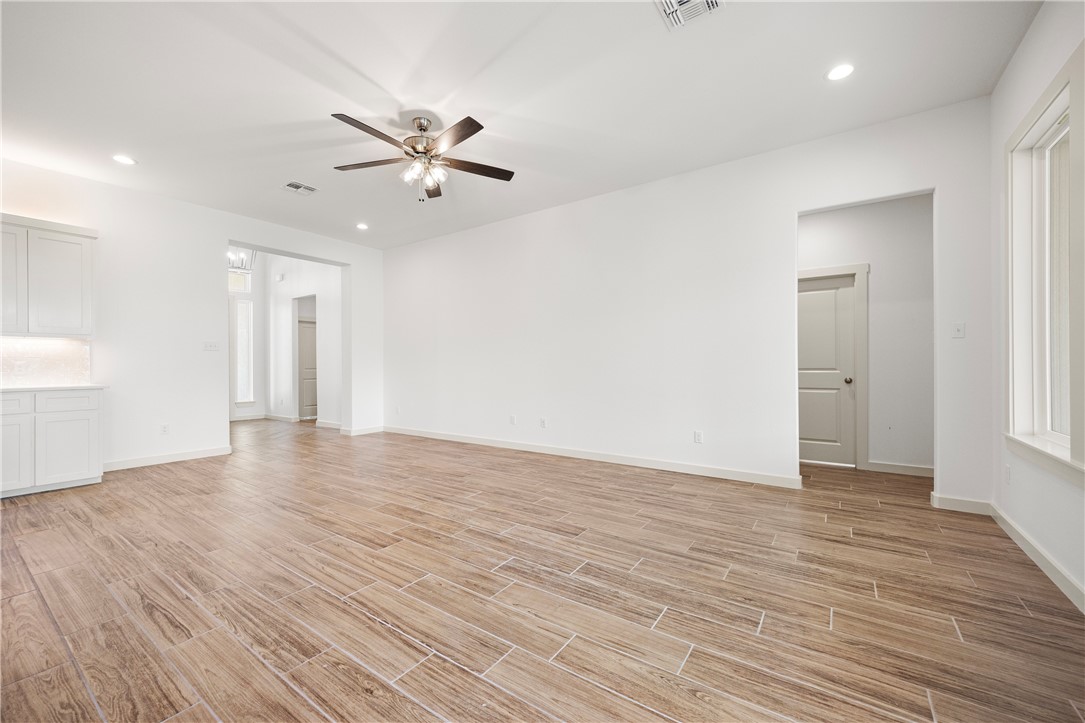 1702 Elm View Drive Corpus Christi, TX 78418 - Photo 5 of 27 a view of an empty room with wooden floor and a ceiling fan