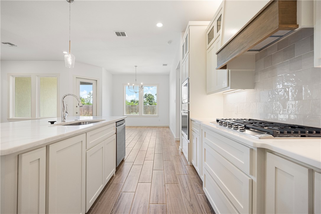 1702 Elm View Drive Corpus Christi, TX 78418 - Photo 8 of 27 a kitchen with white cabinets stove and sink