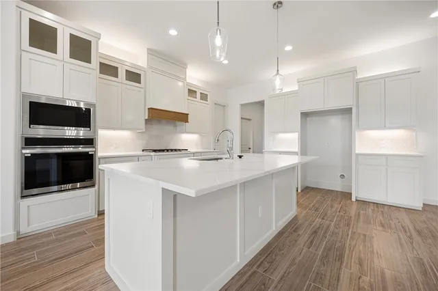 a kitchen with kitchen island a sink stainless steel appliances and cabinets