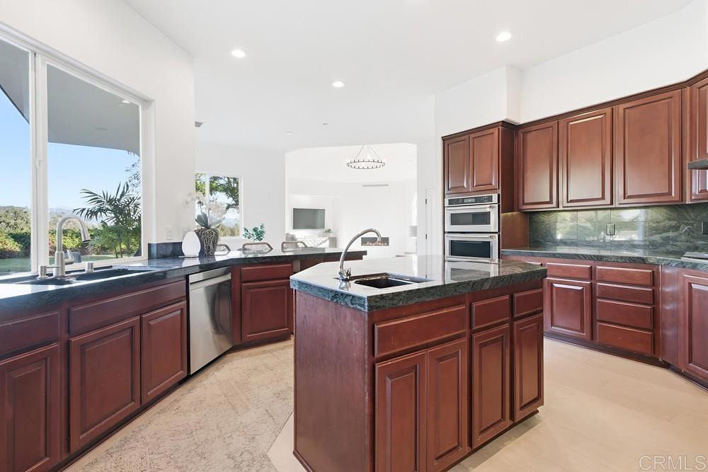 2241 Via Corto Fallbrook, CA 92028 - Photo 23 of 66 a kitchen with stainless steel appliances granite countertop a sink stove and cabinets